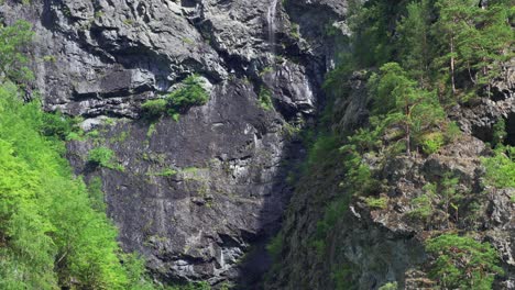 Steep,-dark,-jagged-cliffs-rise-from-the-waters-of-the-Naeroy-fjord