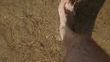 pov-shot-Of-Man-Walking-Barefooted-On-A-Shallow-water-Sunny-Day