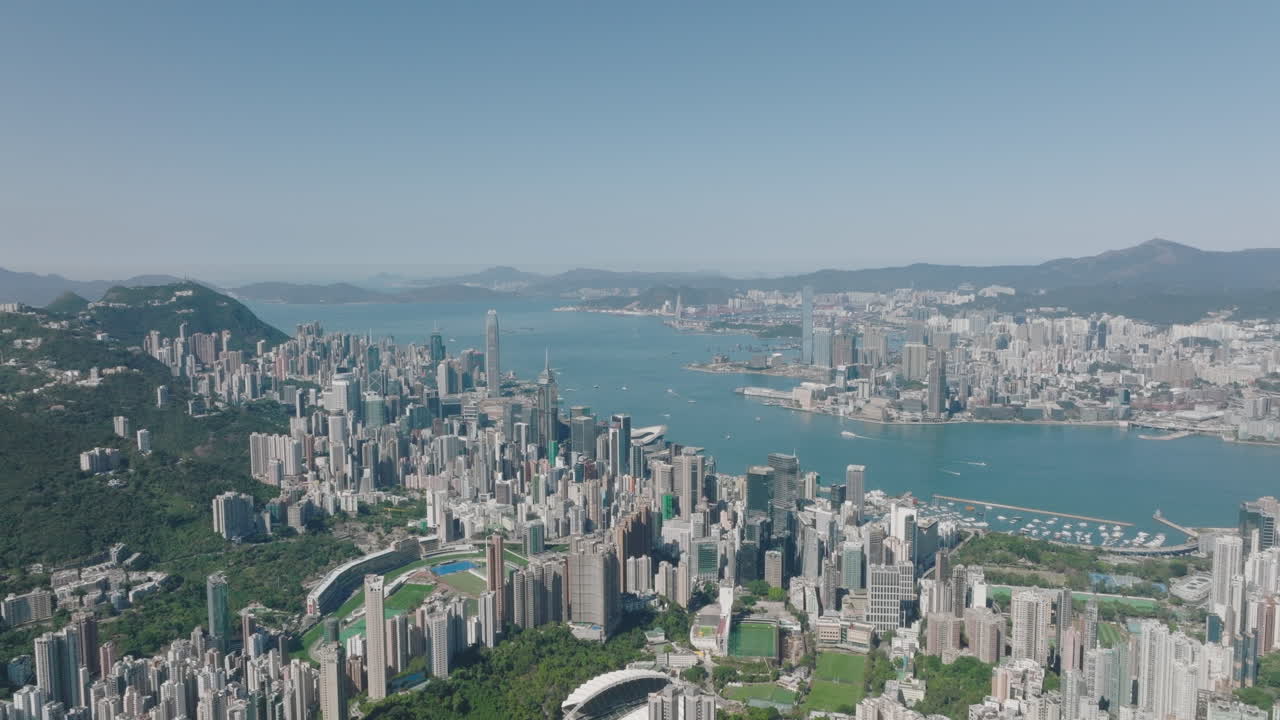 Szerokie ujęcie z dźwigu z lotu ptaka nad Zatoką Wiktorii, z wyspą Hongkong po lewej i Kowloon po prawej