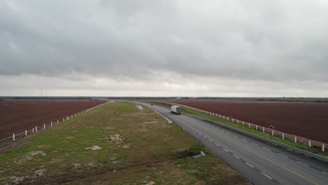 AERIAL---Truck-on-empty-highway,-cloudy-day,-Reynosa,-Tamaulipas,-Mexico,-forward