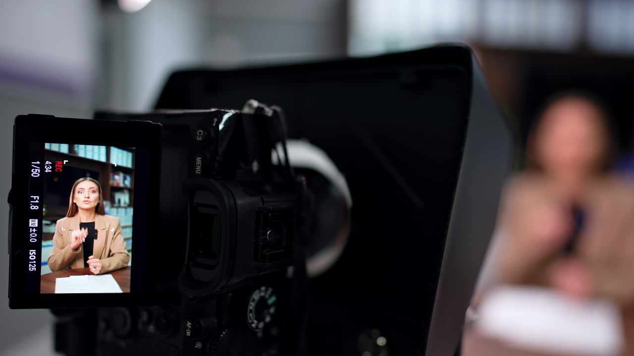 Professional female blogger on the camera display. Close up. Blogger and influencer filming video. Blurred backdrop.