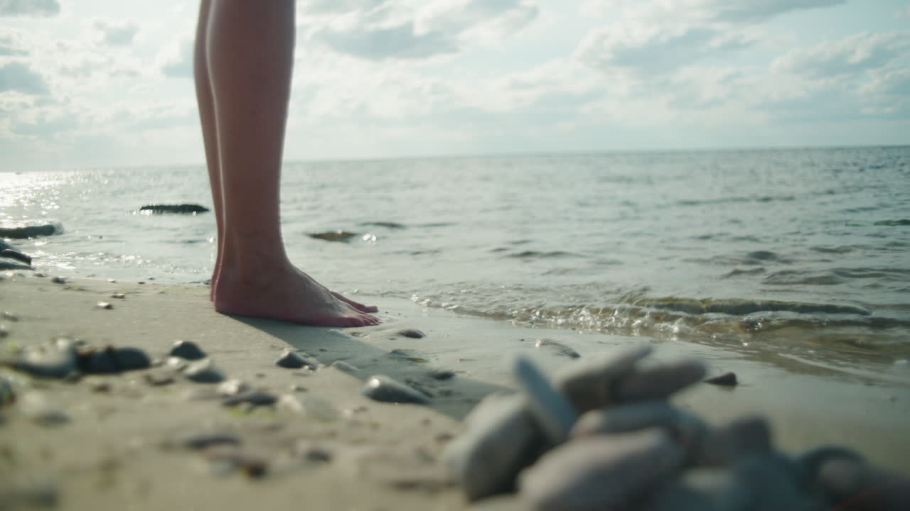 Barefoot women stand by the sea on a sunny day, Sandvik, &Ouml;land Sweden , close up wide