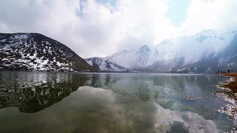 Lagune-Der-Sonne-An-Der-Seite-Mit-Sand-Und-Einigen-Touristen,-Die-Den-Blick-Auf-Den-Schneebedeckten-Gipfel-Des-Vulkans-Nevado-De-Toluca-Genießen