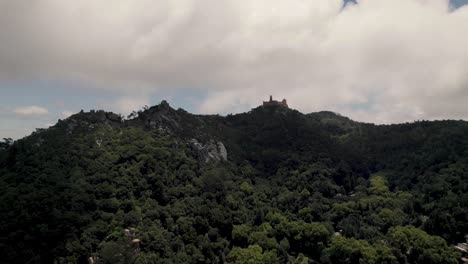 sintra's natural park with distant hilltop pena palace against cloudy sky