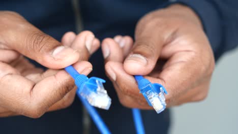 Person holding two ethernet cables