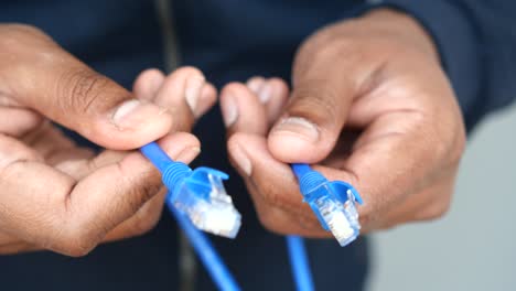 person holding two ethernet cables