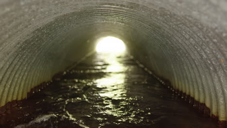 rainwater flowing through corrugated stormwater drainage pipe, pedestal shot