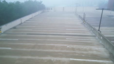 drone trucking pan across thick foggy upper level of parking garage, white mist