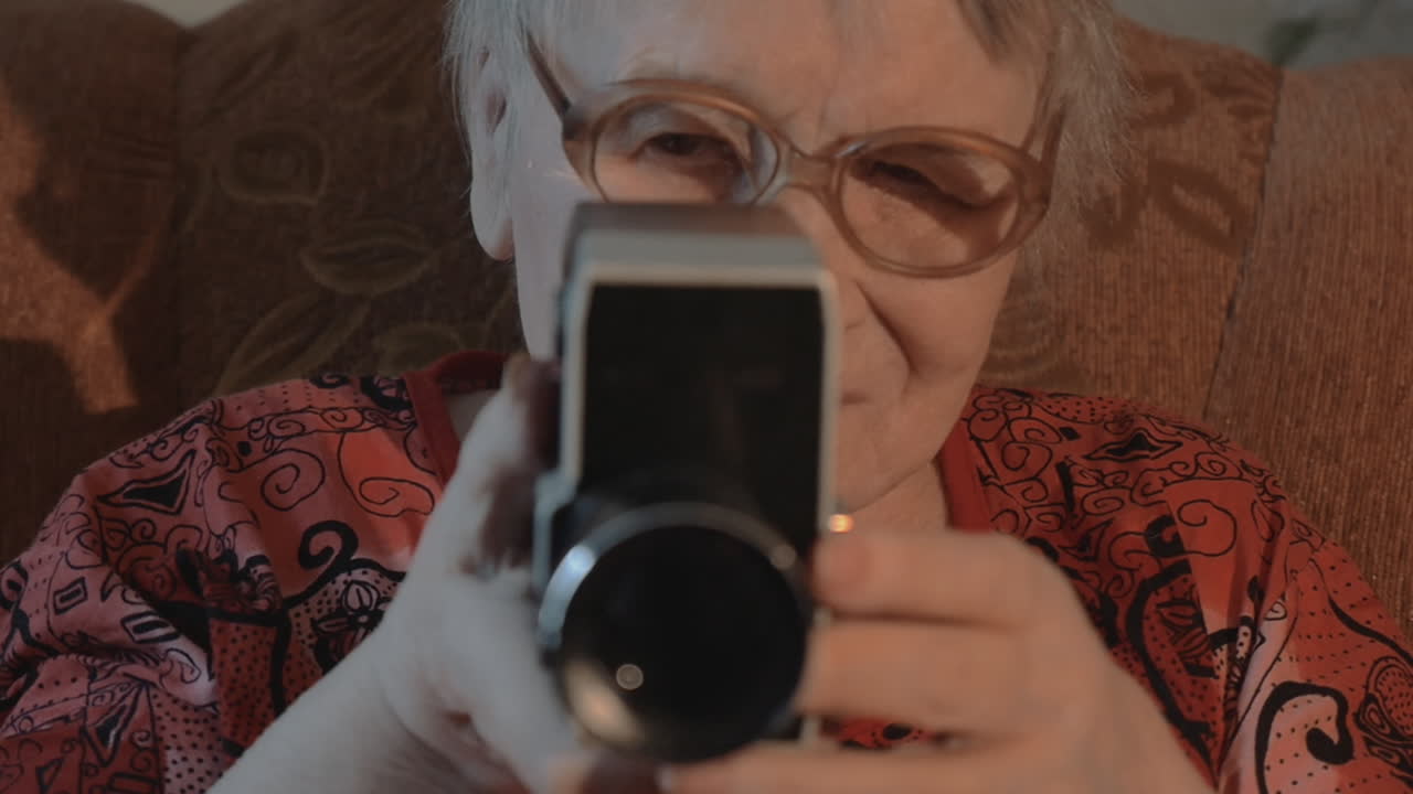 mujer mayor filmando con una cámara de video retro