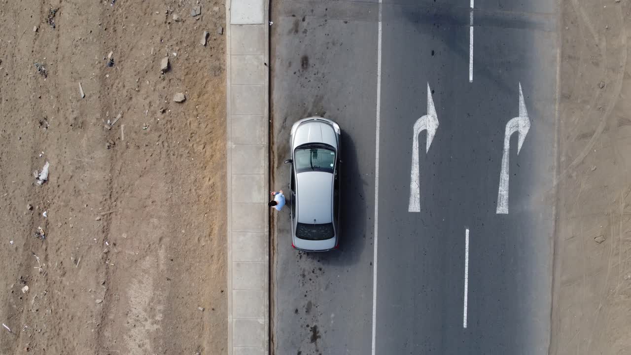 은색 차에서 내리는 사람의 드론 탑다운 영상