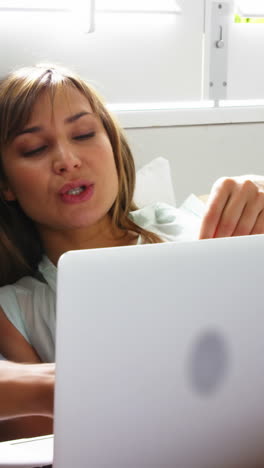 pareja feliz acostada en la cama haciendo compras por internet