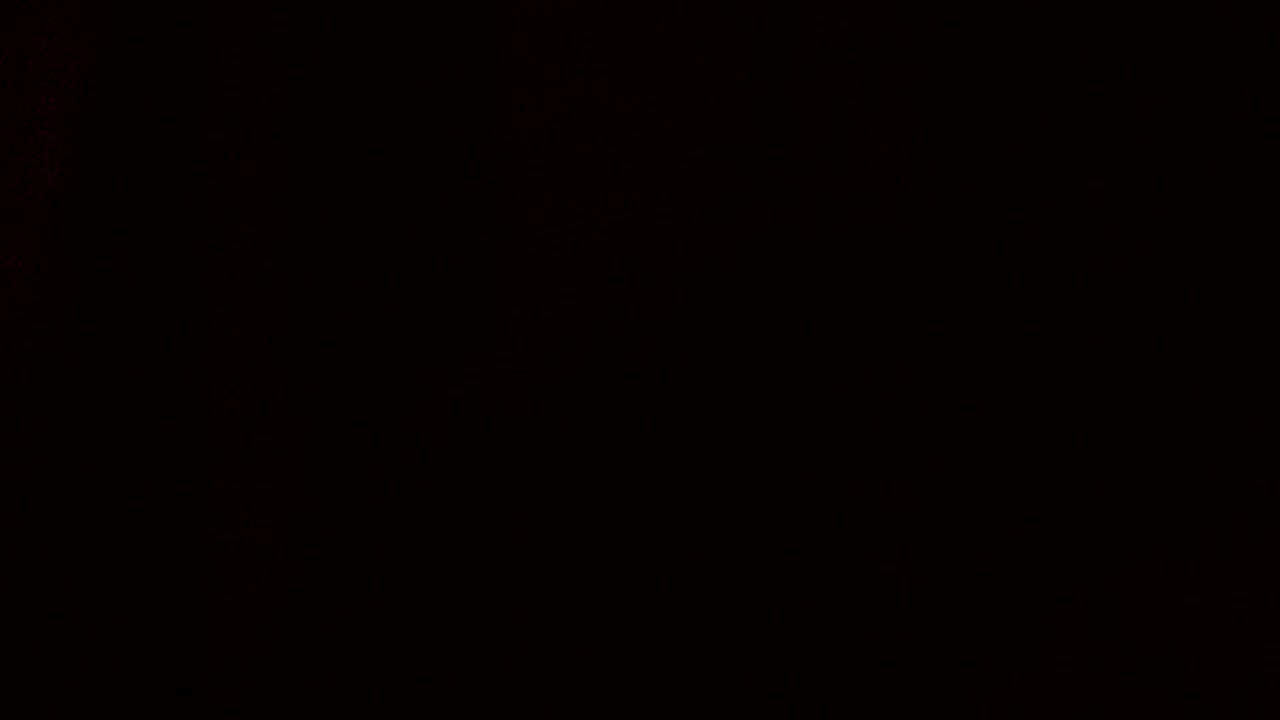 Cash money falling past screen against a black background in slow motion close up