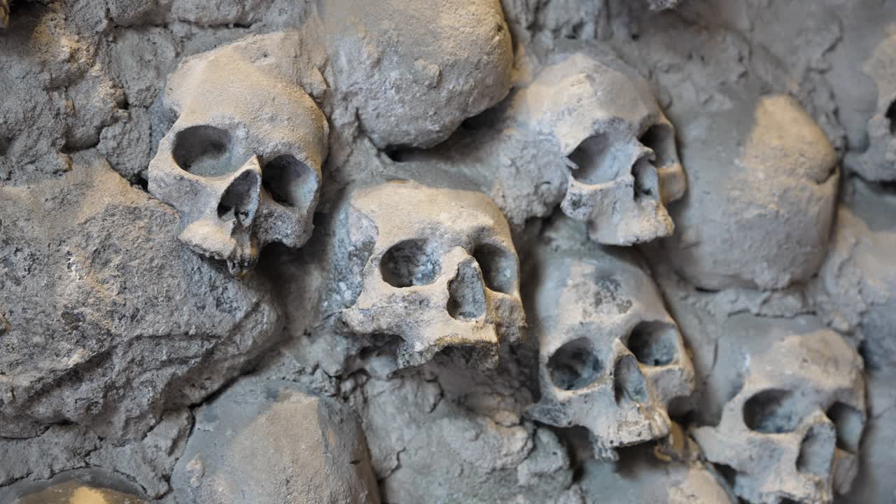Ancient skulls embedded in stone wall, evoke mystery and history