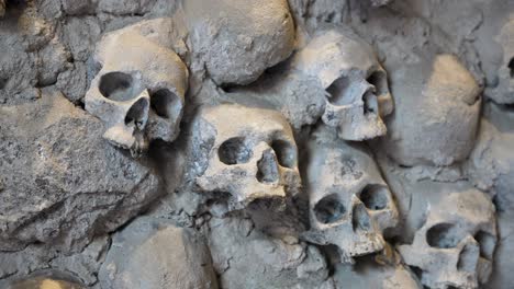 ancient skulls embedded in stone wall, evoke mystery and history