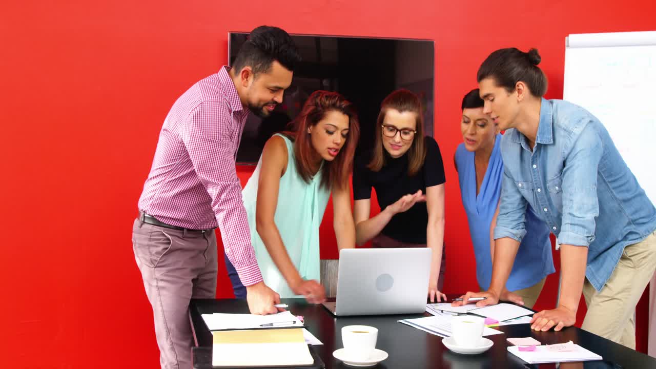 grupo de ejecutivos discutiendo sobre computadora portátil en la sala de conferencias
