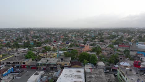 el dron se cierne sobre los tejados residenciales sucios en santo domingo mientras los teleféricos rojos, blancos y azules pasan entre sí, aéreo, república dominicana