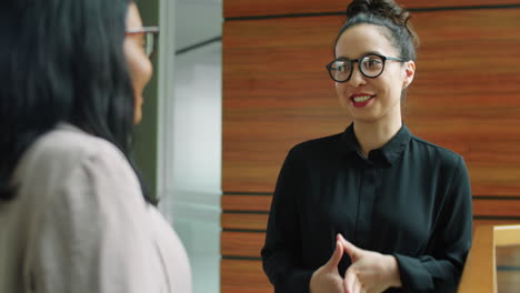 mujer de negocios hablando con una colega.