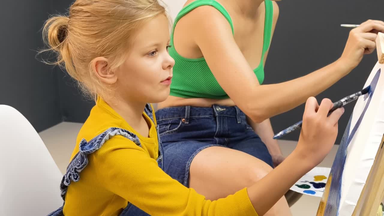 딸이 어머니와 함께 그림을 그리고 있습니다.