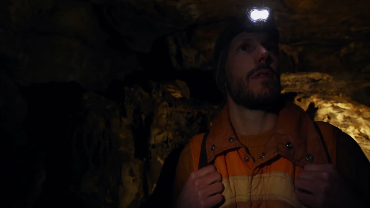 excursionista masculino explorando una cueva oscura 4k