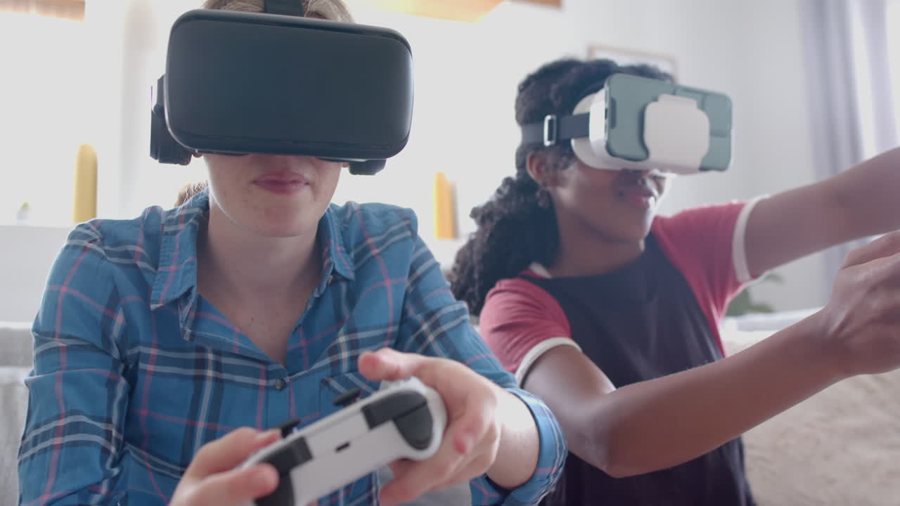 amigas adolescentes felices y diversas jugando videojuegos con auriculares vr en casa, en cámara lenta