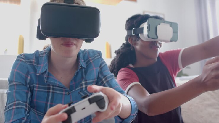 Felici amiche adolescenti di diverse etnie che giocano ai videogiochi con visori VR a casa, rallentatore