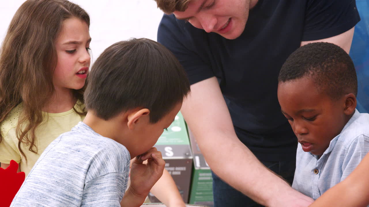 maestro y niños de la escuela haciendo un rompecabezas de ciencia