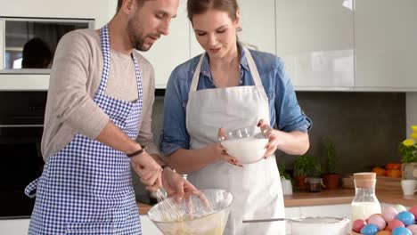 young couple baking cookies for easter