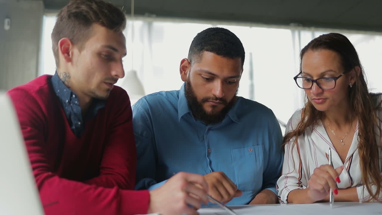 Gruppo di giovani che studiano documenti in ufficio