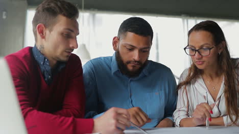 gruppe junger menschen, die dokumente im büro studieren.