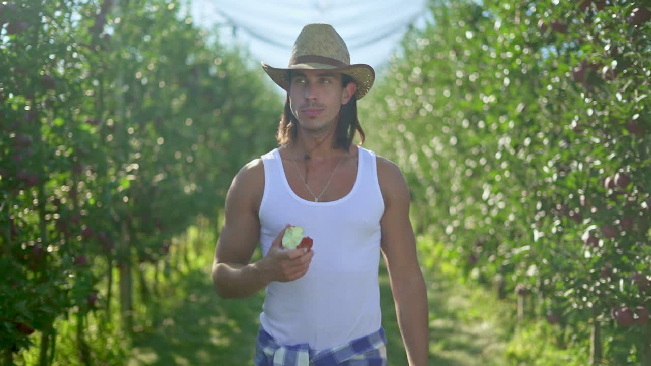 사과 정원에서 사과를 먹는 남자