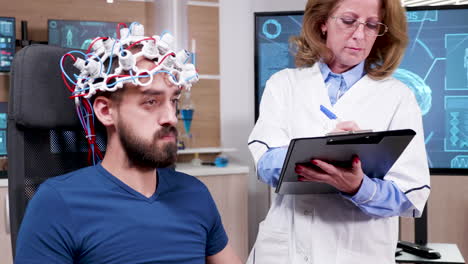 female scientist in brain activity taking notes on her clipboard