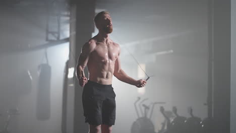 Young-man-exercising-using-skipping-rope-in-gym.-Athletic-man-training-hard-at-the-gym.