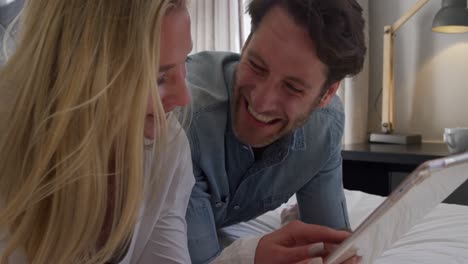 una pareja joven mirando una almohadilla táctil juntos