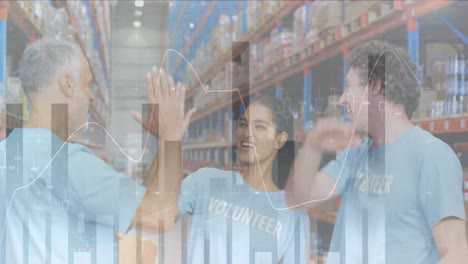 Financial-data-processing-against-diverse-volunteers-high-fiving-each-other-at-warehouse