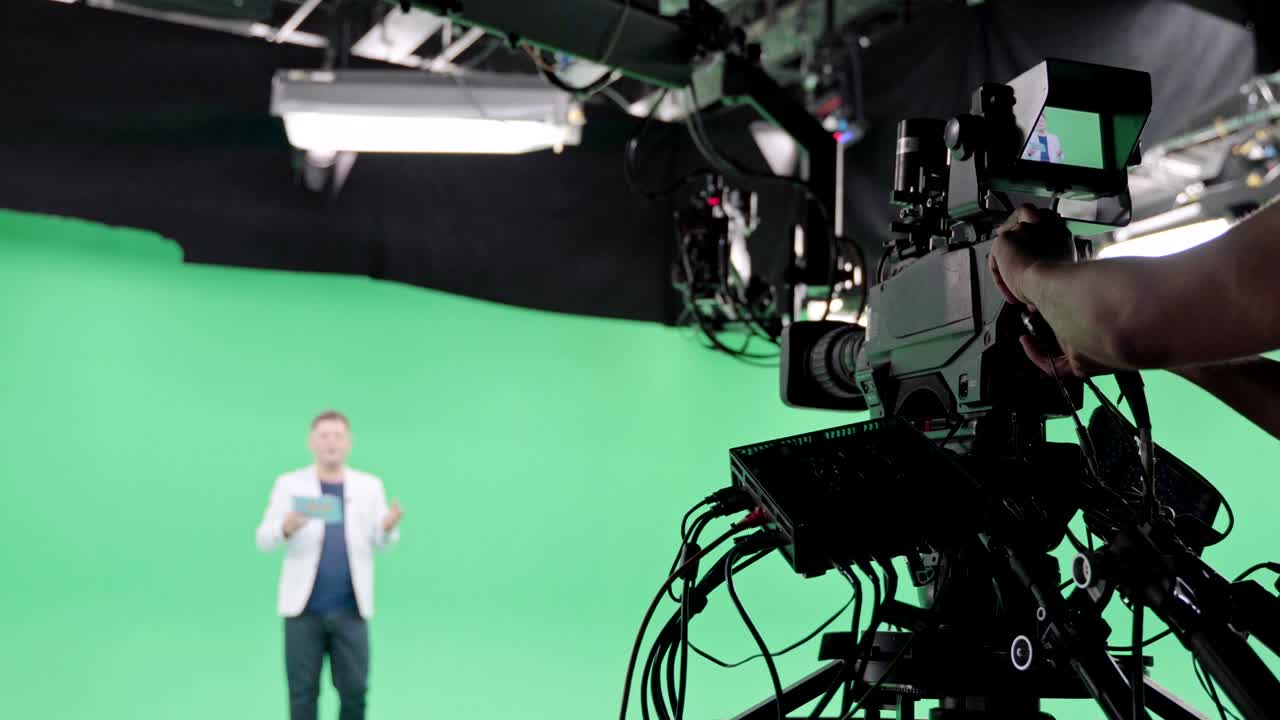 equipo de filmación en el estudio verde de rodaje de video. croma - tecnología de combinar dos o más imágenes o cuadros en una sola composición. camarógrafo, director, equipo. industria cinematográfica.