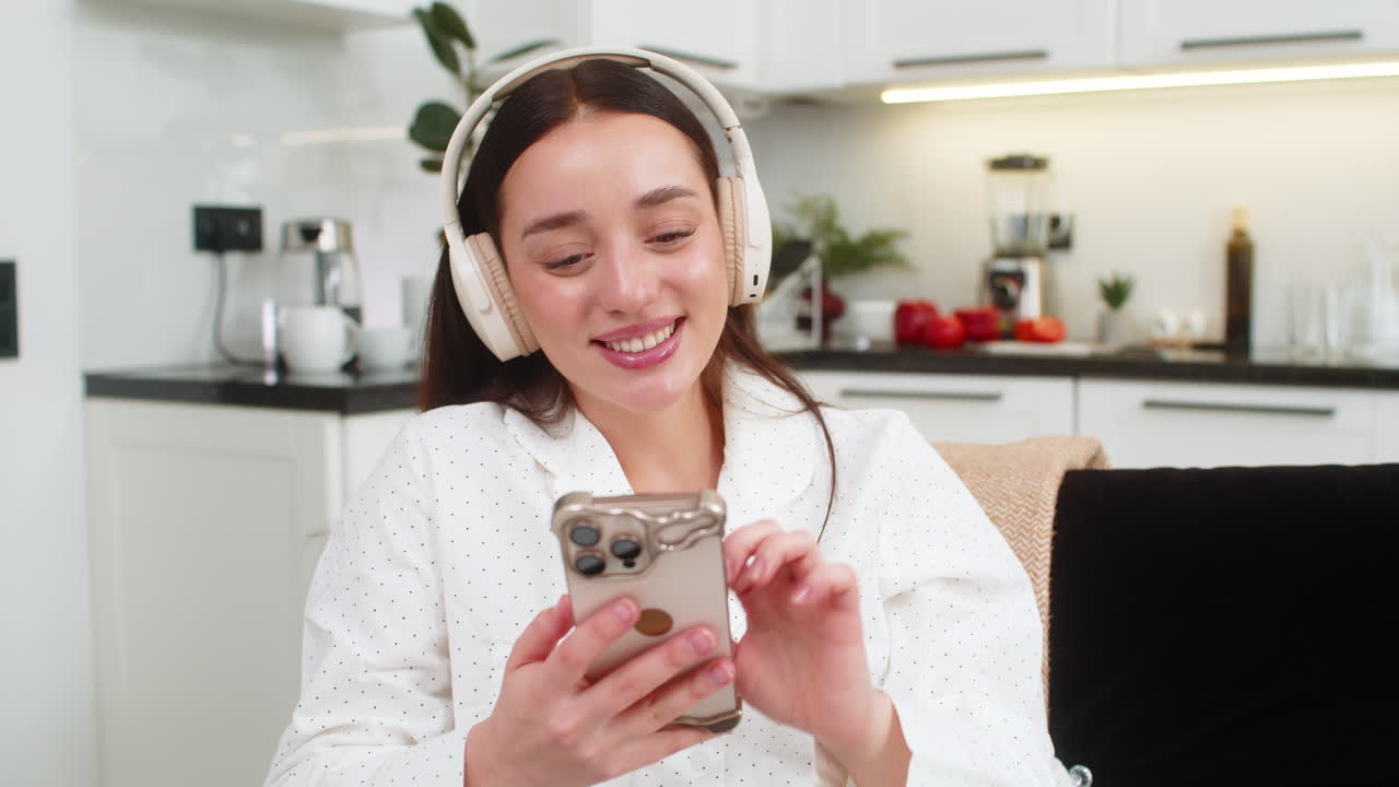 Giovane donna con cuffie wireless ascolta musica con lo smartphone, rilassandosi con gli occhi chiusi
