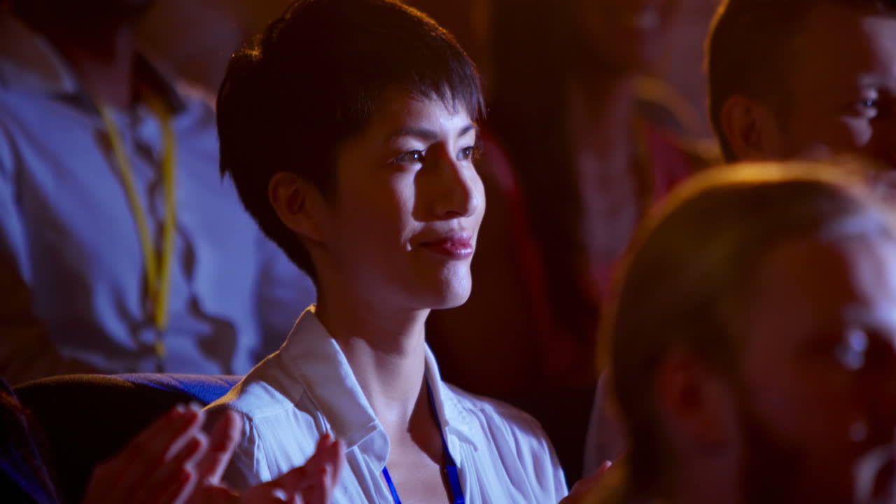 아름다운 아시아 사업가 여성이 오디토리움 4k에서 비즈니스 세미나에서 박수를 치고 있습니다.