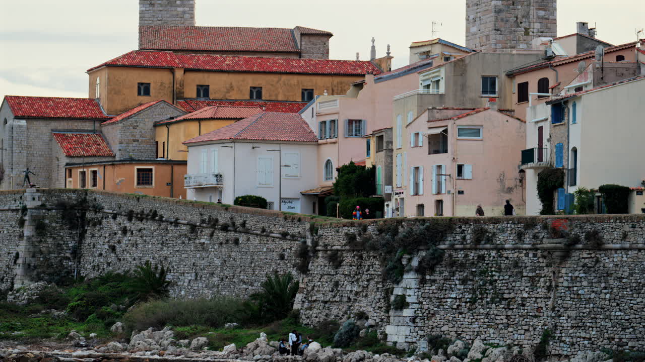 Antibes, France - February 20, 2025: View of people walking near different buildings on the coast