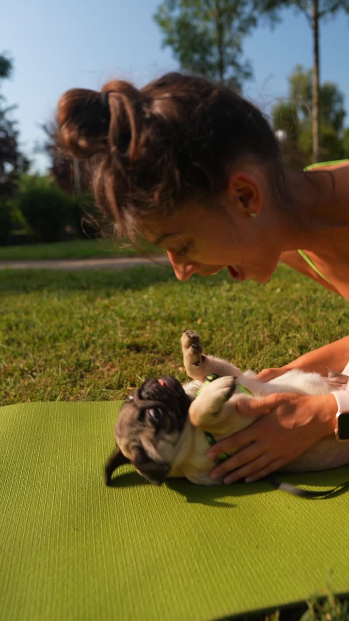 여자 와 파그 강아지 가 공원 에서 놀고 있다