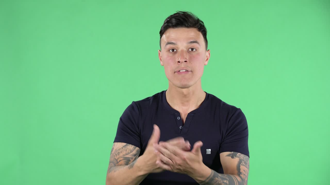 Portrait of a handsome young guy is looking at camera with anticipation and then very upset. Green screen