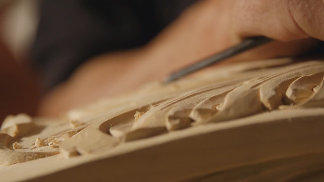 Close-up of a Craftsman's Hands Skillfully Carving Intricate Designs into Wood