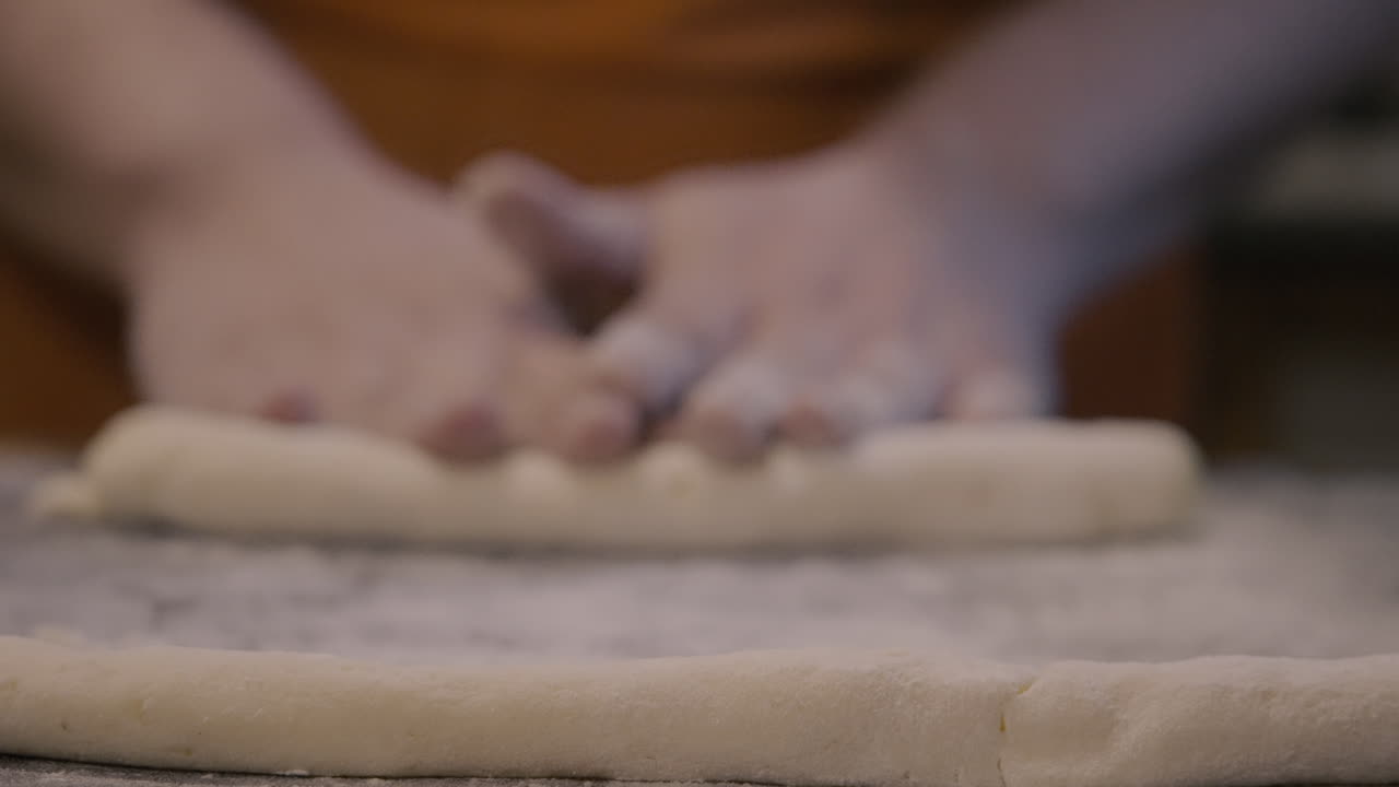 Close-Up of Hands Rolling Dough on a Floured Surface