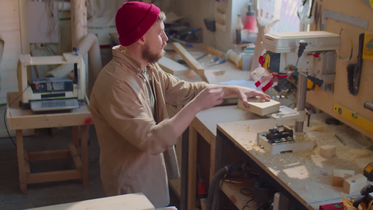 Carpenter Using Drill Press Machine in Workshop
