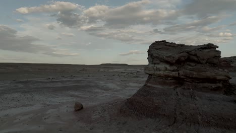 pullback aerial reveal of eroded buttes in a barren desert landscape