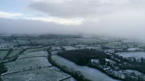 Aerial-tracking-sideways-across-a-frozen-and-snowy-looking-English-countryside