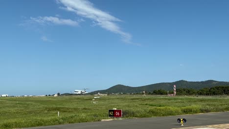 medium size white jet landing at ibiza’s airport, runway 06