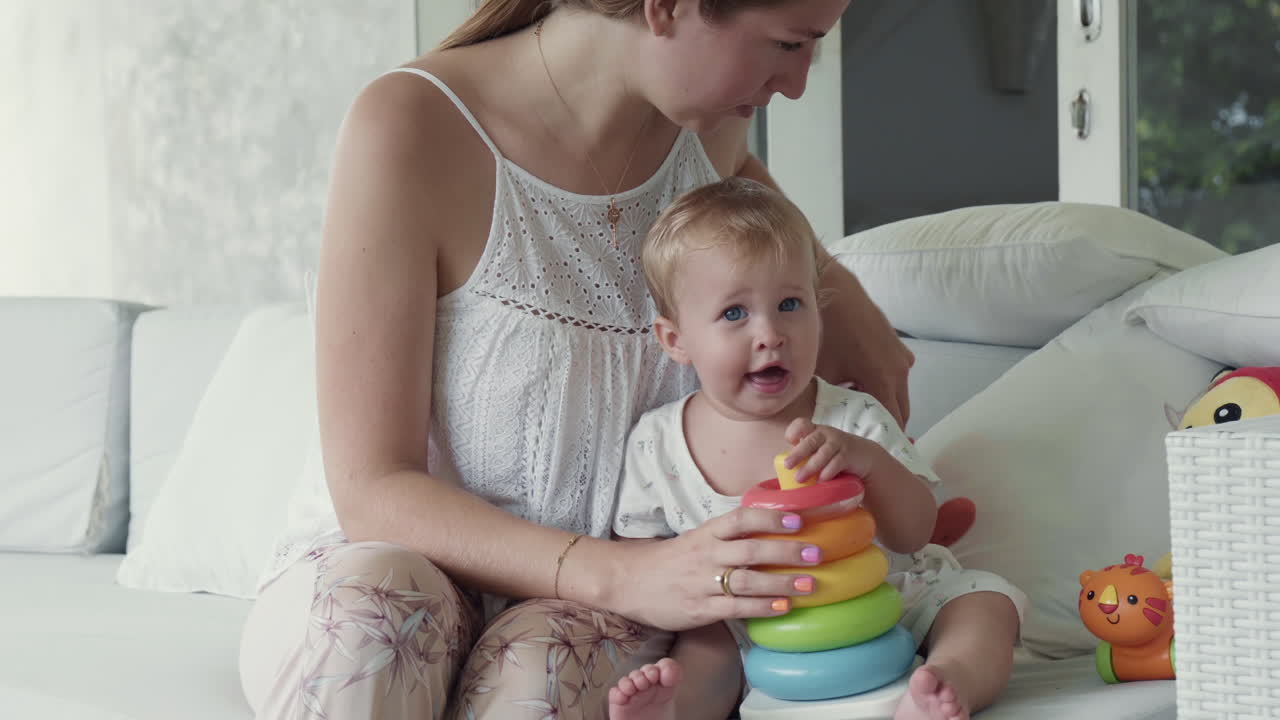 Niño pequeño jugando con una pirámide de aros de juguete