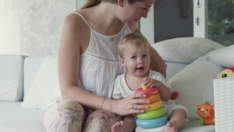 toddler playing with toy ring pyramid