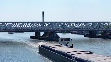 "aquarius" river cargo boat passes under traffic-clogged bridge