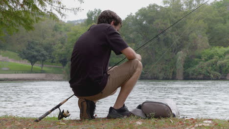 man fishing by the river bank